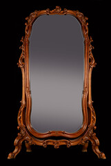 Large antique baroque mirror on curved wooden legs in a decorative wooden vintage carved frame, isolated on a black background