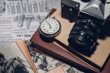 old camera, glasses and watch on newspaper background