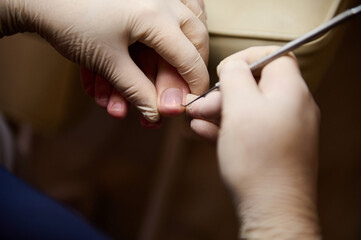 Close-up of a podiatrist chiropodist cleaning woman's feet in beauty salon. Process of pedicure