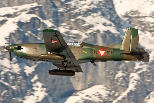 Austrian Air Force Bundesheer Pilatus PC-7 with gun pods taking off in Innsbruck in winter terrain for an air patrouille mission during the WEF in Davos