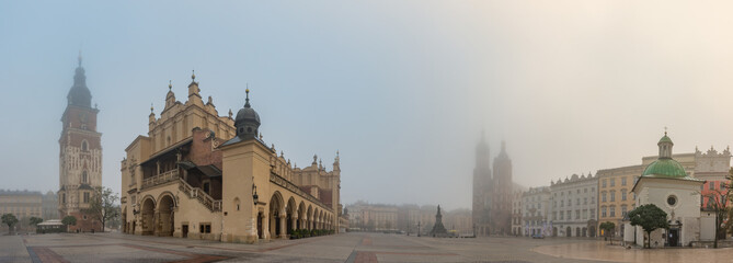 Krakow, Poland, main square panorama with Cloth Hall and St Mary's church on foggy November morning