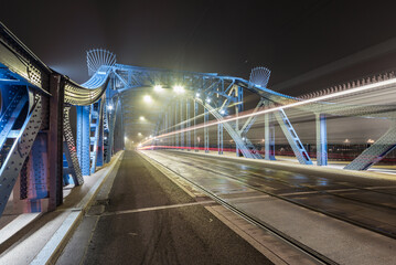Krakow Poland, tram light trails on Pilsudski bridge over Vistula river in the night