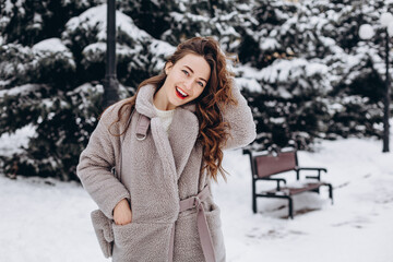 Pretty girl having a walk in park at winter