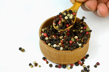 Chef taking dry spices mixture of different colored peppers peas from wooden spice jar. - 469379340