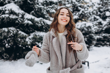 Girl walking in a snowy park laughing and wearing a coat