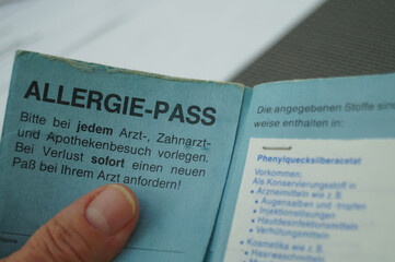 Frau hält ihren Allergie Pass in den Händen