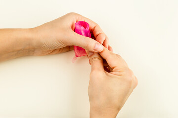 Female hands showing how to use a Menstrual Cup