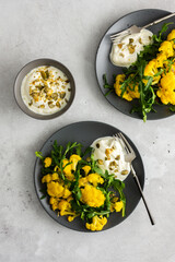 Salad with yellow cauliflower and arugula, Greek yogurt and pumpkin seeds, a light healthy breakfast, top view