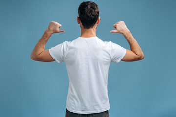 Back view of the caucasian man in T-shirt pointing at himself, while being proud and satisfied....