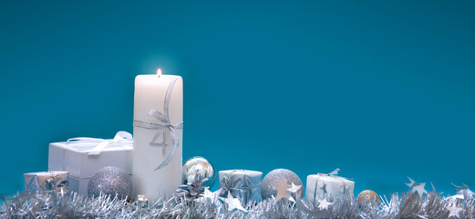Fourth Advent. Christmas background with Advent candle and silver decoration.
