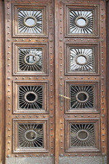 antique brown wooden entrance bivalve door with glass and wrought decor