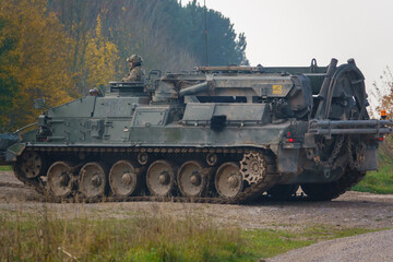 close up full-side view of a British Army Challenger Armored Repair and Recovery Vehicle (CRARRV) in action on a military training exercise, salisbury plain wiltshire UK
