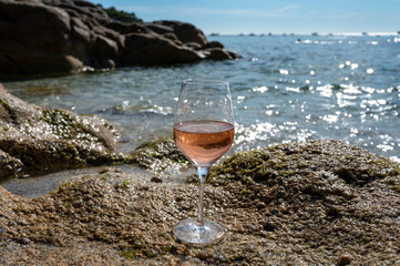 Summer time in Provence, glass of cold rose wine on sandy beach and blue sea near Saint-Tropez, Var department, France