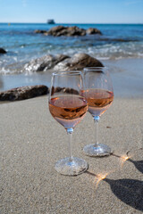 Summer time in Provence, two glasses of cold rose wine on sandy beach near Saint-Tropez, Var department, France