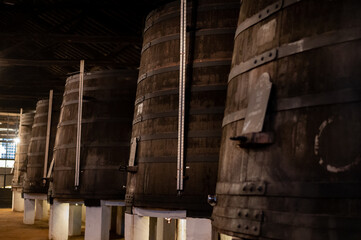 Old porto lodge with rows of oak wooden casks for slow aging of fortified ruby or tawny porto wine in Vila Nova de Gaia, Portugal