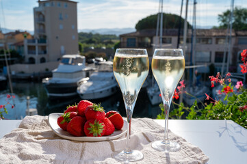 Summer party, drinking of French champagne sparkling wine in glasses in yacht harbour of Port Grimaud near Saint-Tropez, French Riviera vacation, France