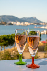 Summer party, drinking of French champagne rose sparkling wine in glasses with view on fishermen harbour of Toulon, France