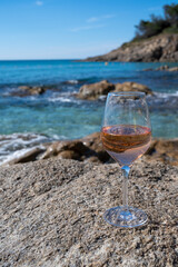Summer time in Provence, glass of cold rose wine on sandy beach and blue sea near Saint-Tropez, Var department, France