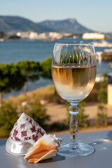 Summer on French Riviera, drinking of cold white or gris rose wine from Cotes de Provence on outdoor terrase with view on harbour of Toulon, Var, France and sea shells