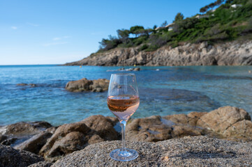 Summer time in Provence, glass of cold rose wine on sandy beach and blue sea near Saint-Tropez, Var...