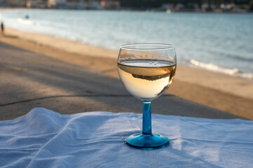 Summer time in Provence, drinking of cold gris rose wine on sandy beach and blue sea near Toulon, Var department, France