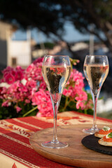 Drinking of white cold champagne, bliny with red caviar and view on Port Grimaud near Saint-Tropez in summer