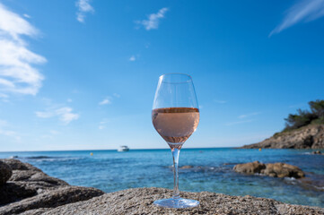 Summer time in Provence, glass of cold rose wine on sandy beach and blue sea near Saint-Tropez, Var department, France