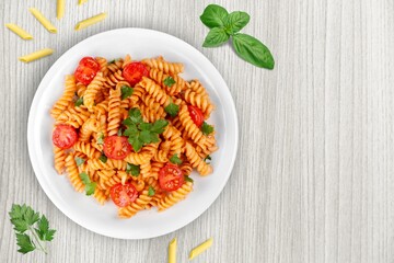 Tasty pasta dish with tomato sauce and cheese on the desk
