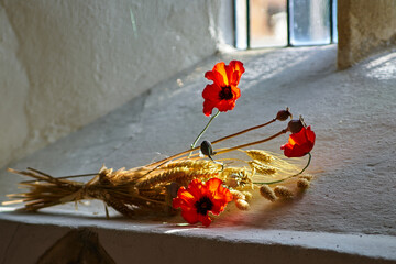 Poppies and wheat lying on church window sill