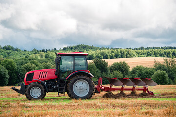 Obraz premium Farmer in tractor plowing the land in autumn