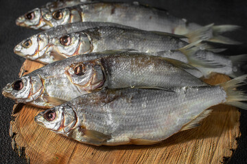 Ready-made silver bream fish, dried, dry, salted, appetizing laid out on a dark background. Catch river, fishing.