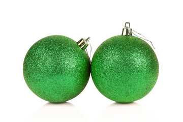 Two green glittered Christmas balls isolated on white background with reflection