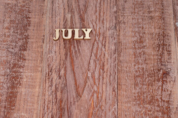 July month. The name of the months on a wooden background. Template for a calendar.