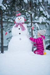Cute girl is making a snowman.