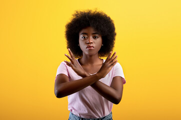 Refusal concept. Upset black lady showing stop gesture with crossed hands, refusing something...