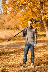 A man with a rake standing in the park