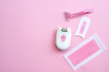 Pink epilator with wax strips and razor for removal of unwanted hair. Flat lay - obrazy, fototapety, plakaty
