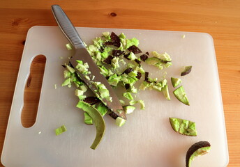 Chopped up avocados. Close up at a cutting board with a shiny knife.
Concept of making a tasty and...