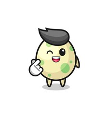 spotted egg character doing Korean finger heart