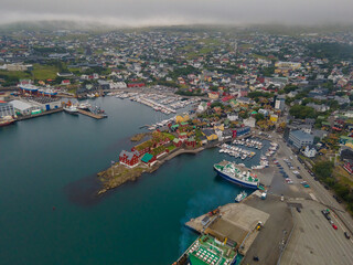 Fototapeta na wymiar Beautiful aerial view of the City of Torshavn Capital of Faroe Islands- View of Cathedral, colorful buildings, marina, suburbs and Flag