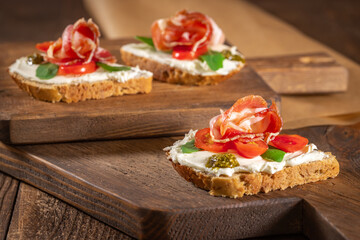 Italian tomato and cheese bruschetta. Antipasto with prosciutto and cherry tomato vegetables