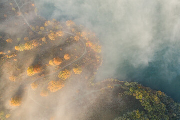 Aerial view of an autumn scene with foggy landscape and a lake