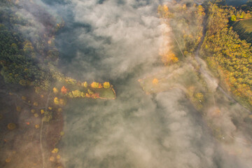 Aerial view of an autumn scene with foggy landscape and a lake