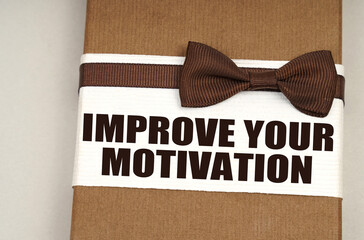 On the packing box with a bow-tie the inscription - Improve Your Motivation