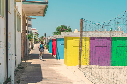 bicycle rider by the colorful beach huts