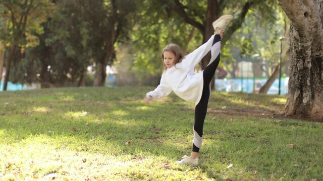 little girl doing exercises in the park