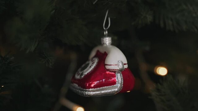 Close-up of woman's hands decorating Christmas tree with telephone toy
