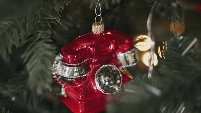 Close-up of woman's hands decorating Christmas tree with telephone toy