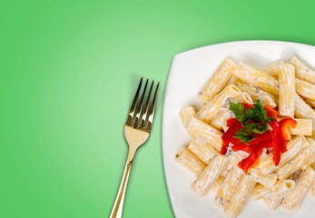 Classic Italian pasta dish with basil and freshly grated parmesan cheese on dark table.
