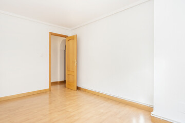 Empty room with light oak floors and carpentry with white painted walls